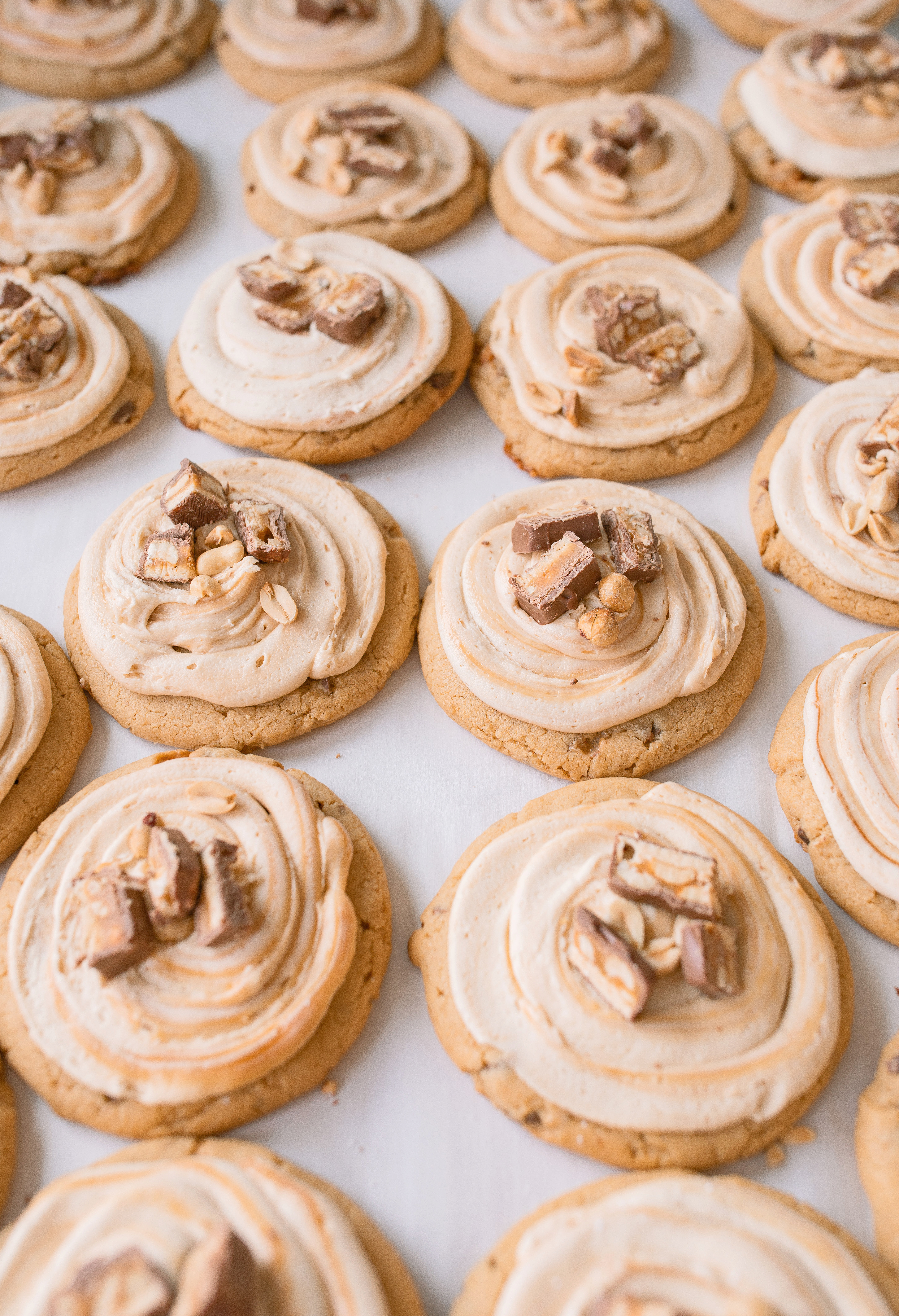 frosted cookies, snickers, dessert, candy bar, homemade salted caramel buttercream, buttercream frosting, peanut butter snickers cookies, peanut butter cookies, amazing dessert ever, the best frosted cookie recipe, salted caramel buttercream, peanut butter cookies, baking, soft, thick cookies, bakery, recipe