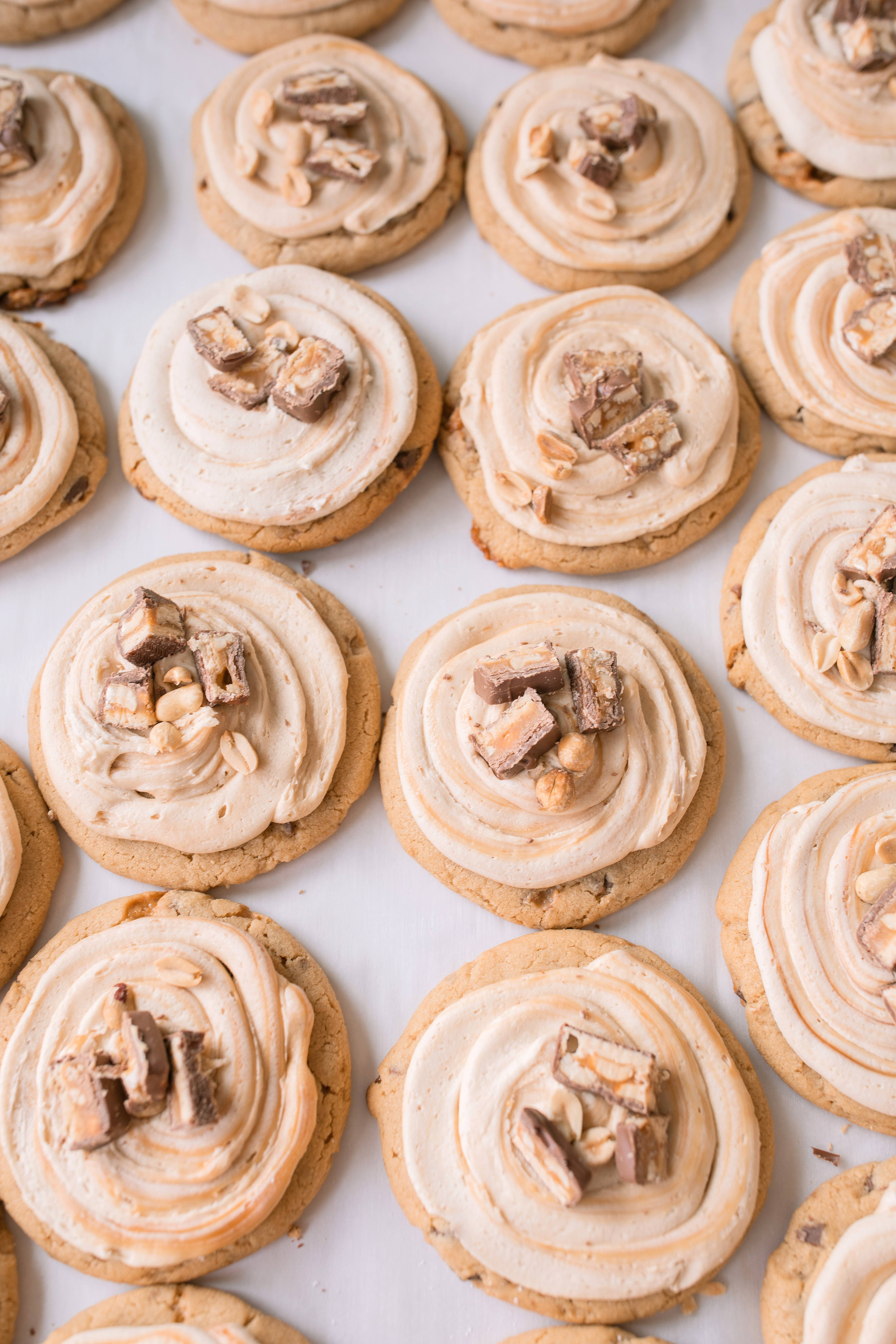 frosted cookies, snickers, dessert, candy bar, homemade salted caramel buttercream, buttercream frosting, peanut butter snickers cookies, peanut butter cookies, amazing dessert ever, the best frosted cookie recipe, salted caramel buttercream, peanut butter cookies, baking, soft, thick cookies, bakery, recipe