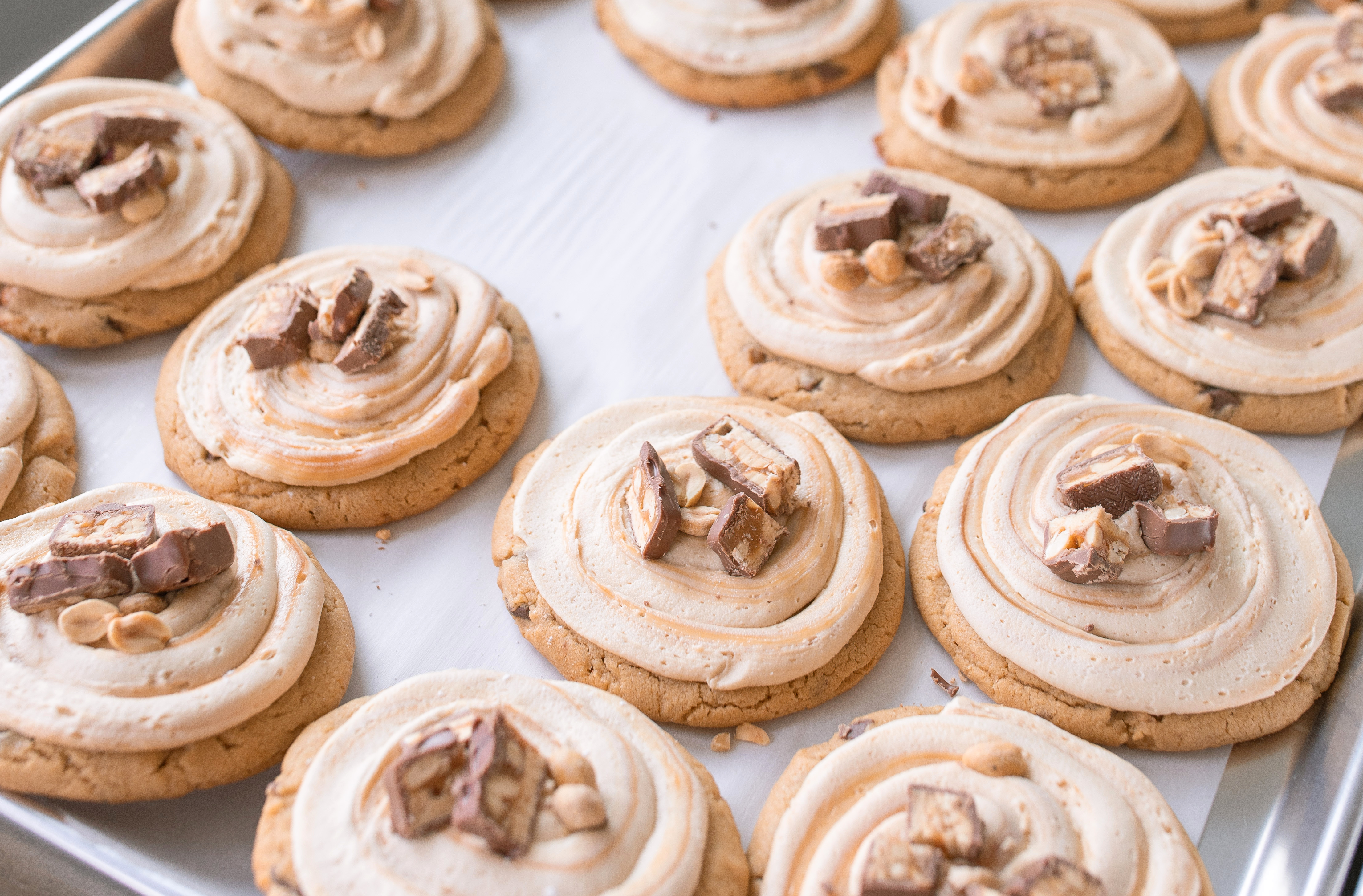 frosted cookies, snickers, dessert, candy bar, homemade salted caramel buttercream, buttercream frosting, peanut butter snickers cookies, peanut butter cookies, amazing dessert ever, the best frosted cookie recipe, salted caramel buttercream, peanut butter cookies, baking, soft, thick cookies, bakery, recipe