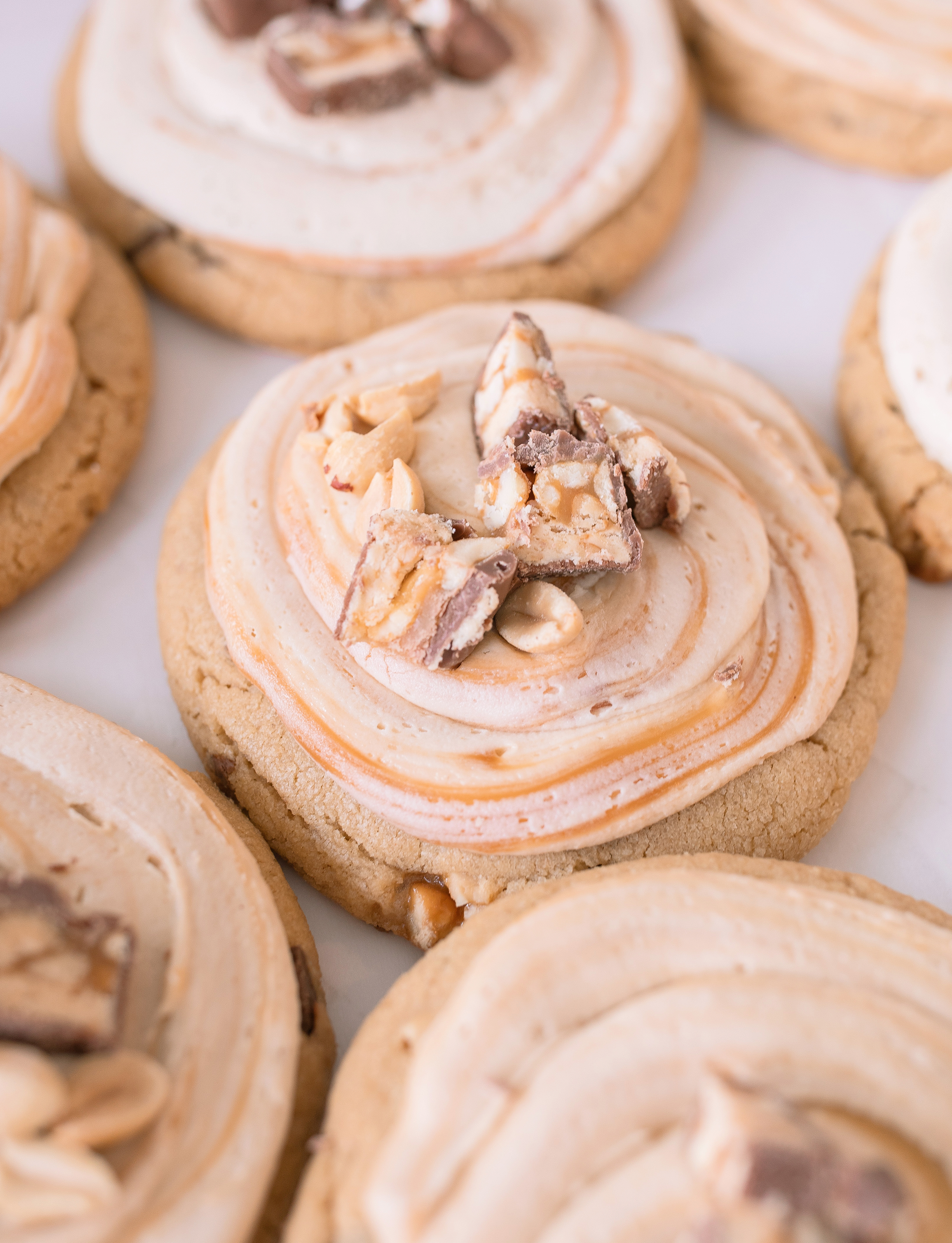 frosted cookies, snickers, dessert, candy bar, homemade salted caramel buttercream, buttercream frosting, peanut butter snickers cookies, peanut butter cookies, amazing dessert ever, the best frosted cookie recipe, salted caramel buttercream, peanut butter cookies, baking, soft, thick cookies, bakery, recipe