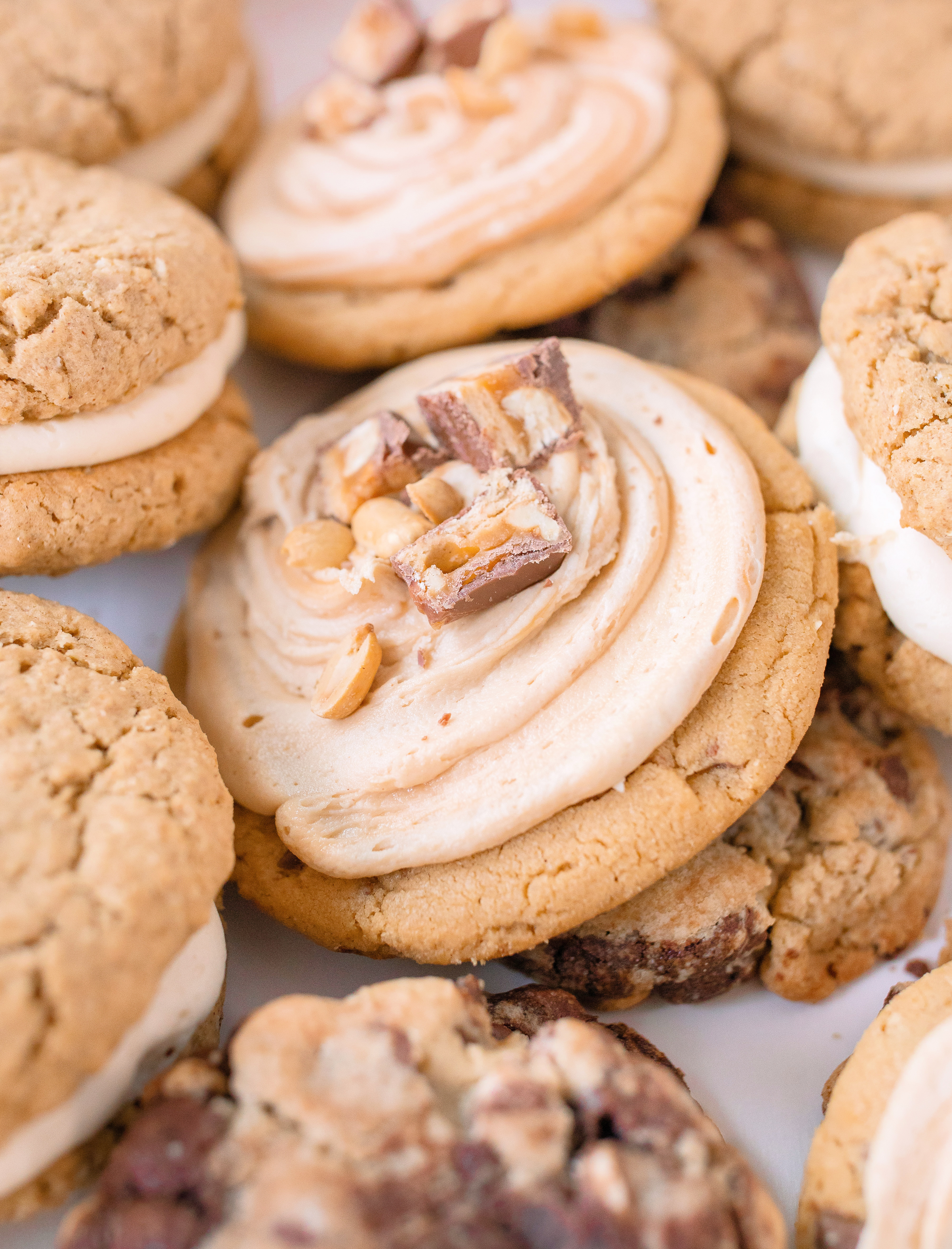 frosted cookies, snickers, dessert, candy bar, homemade salted caramel buttercream, buttercream frosting, peanut butter snickers cookies, peanut butter cookies, amazing dessert ever, the best frosted cookie recipe, salted caramel buttercream, peanut butter cookies, baking, soft, thick cookies, bakery, recipe