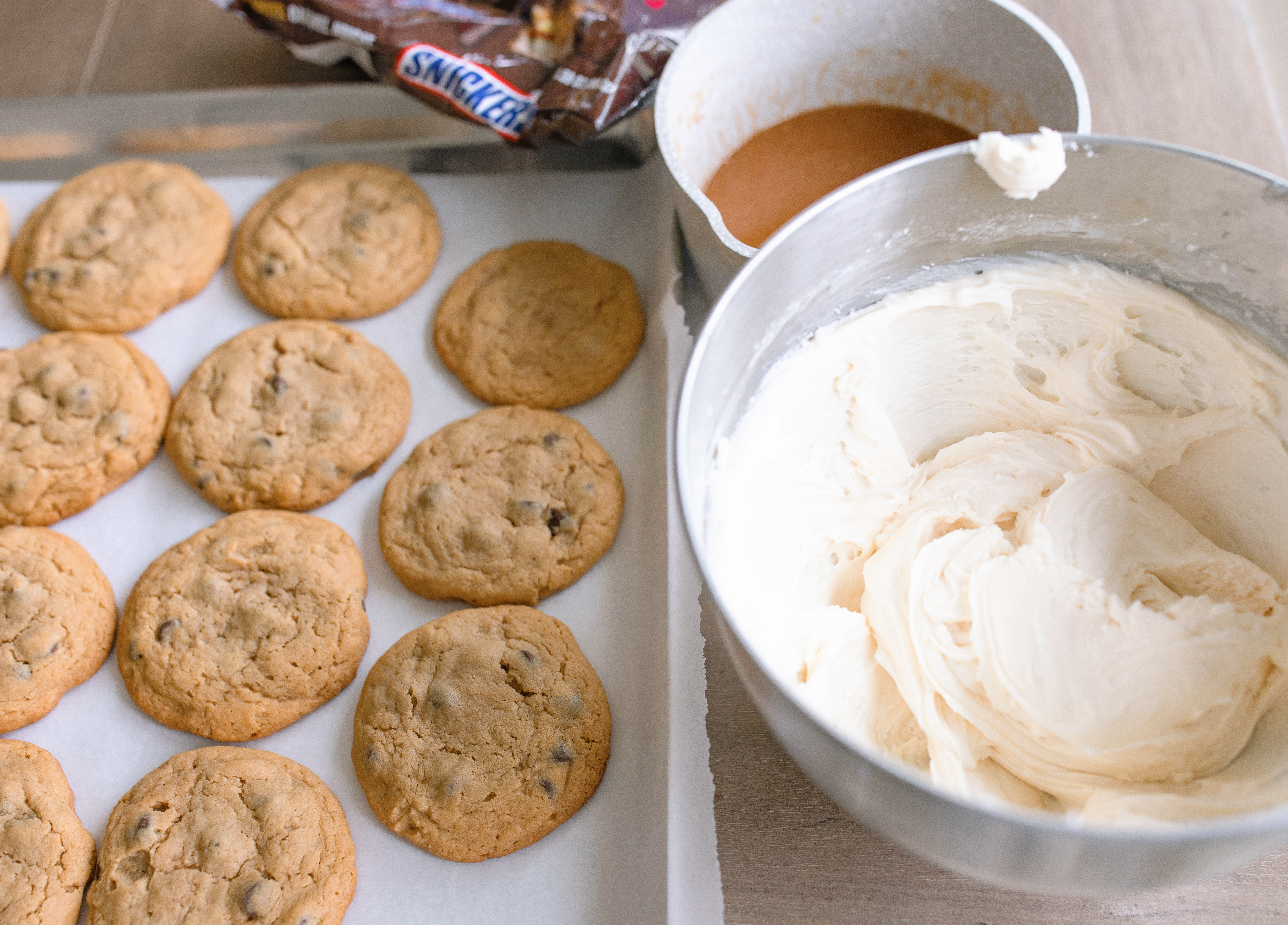 frosted cookies, snickers, dessert, candy bar, homemade salted caramel buttercream, buttercream frosting, peanut butter snickers cookies, peanut butter cookies, amazing dessert ever, the best frosted cookie recipe, salted caramel buttercream, peanut butter cookies, baking, soft, thick cookies, bakery, recipe